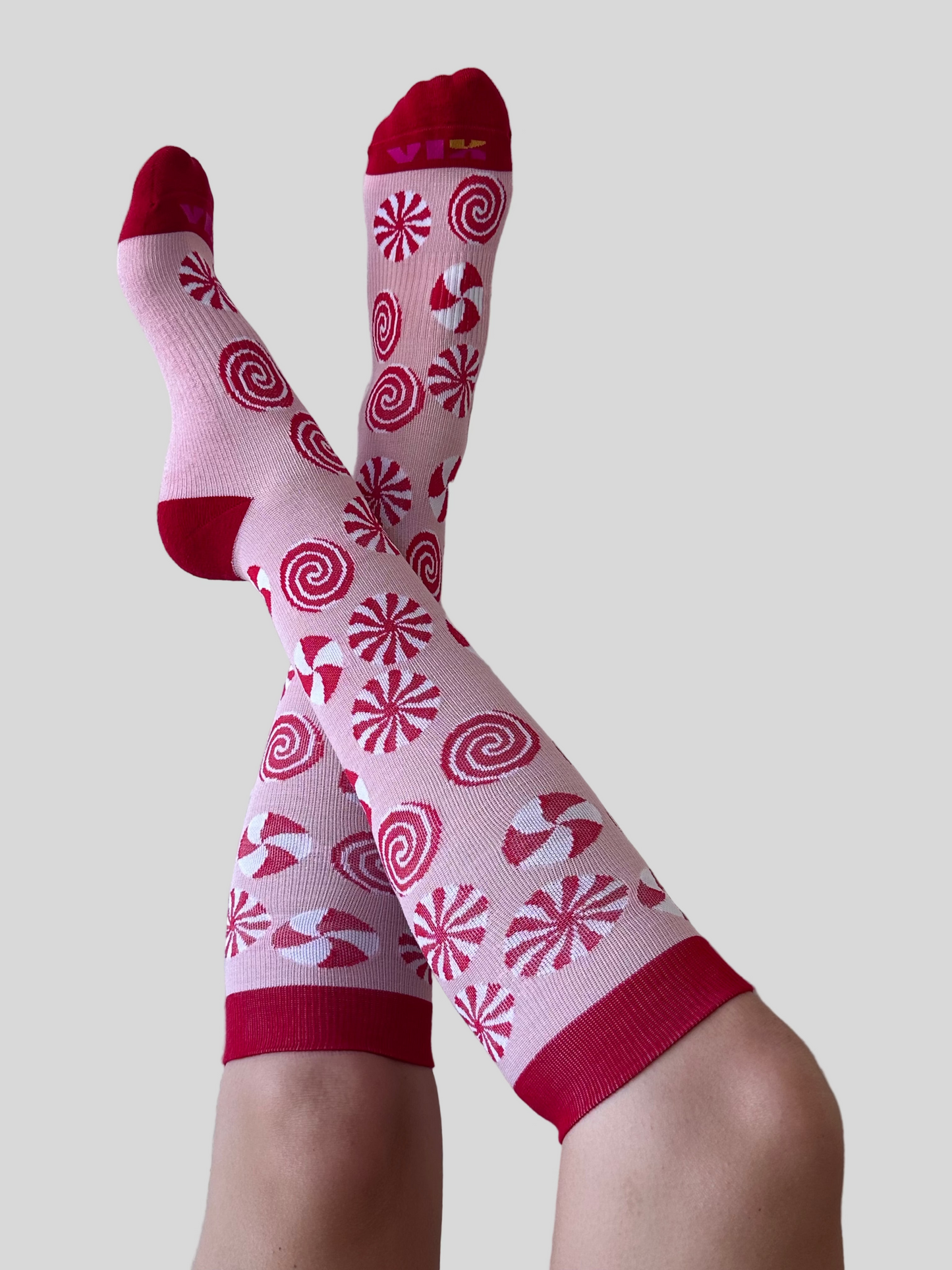 Peppermint designed compression socks by a person against a white wall