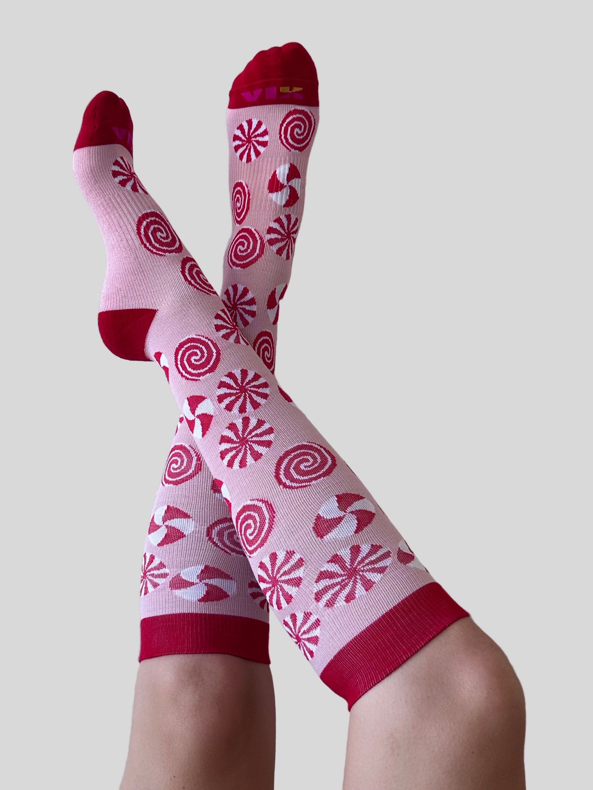 Peppermint designed compression socks by a person against a white wall